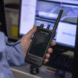 MOTOTRBO Ion smart radio held in hand to demonstrate its ergonomic size and rugged build in a security control room environment.