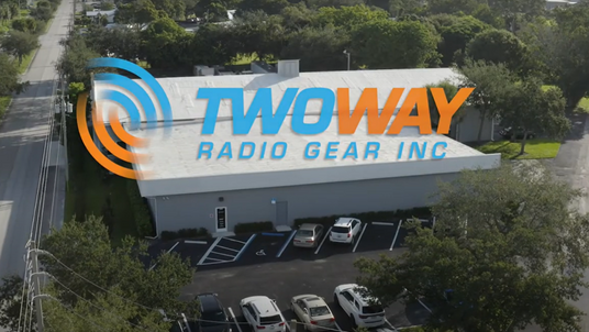 Aerial view of the Two Way Radio Gear Inc. building located at 3245 Okeechobee Road, Fort Pierce, Florida 34947, showcasing the company's headquarters with vehicles parked outside.